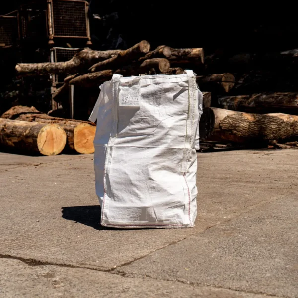 A sealed logstore barrow bag of firewood logs with the log deck behind
